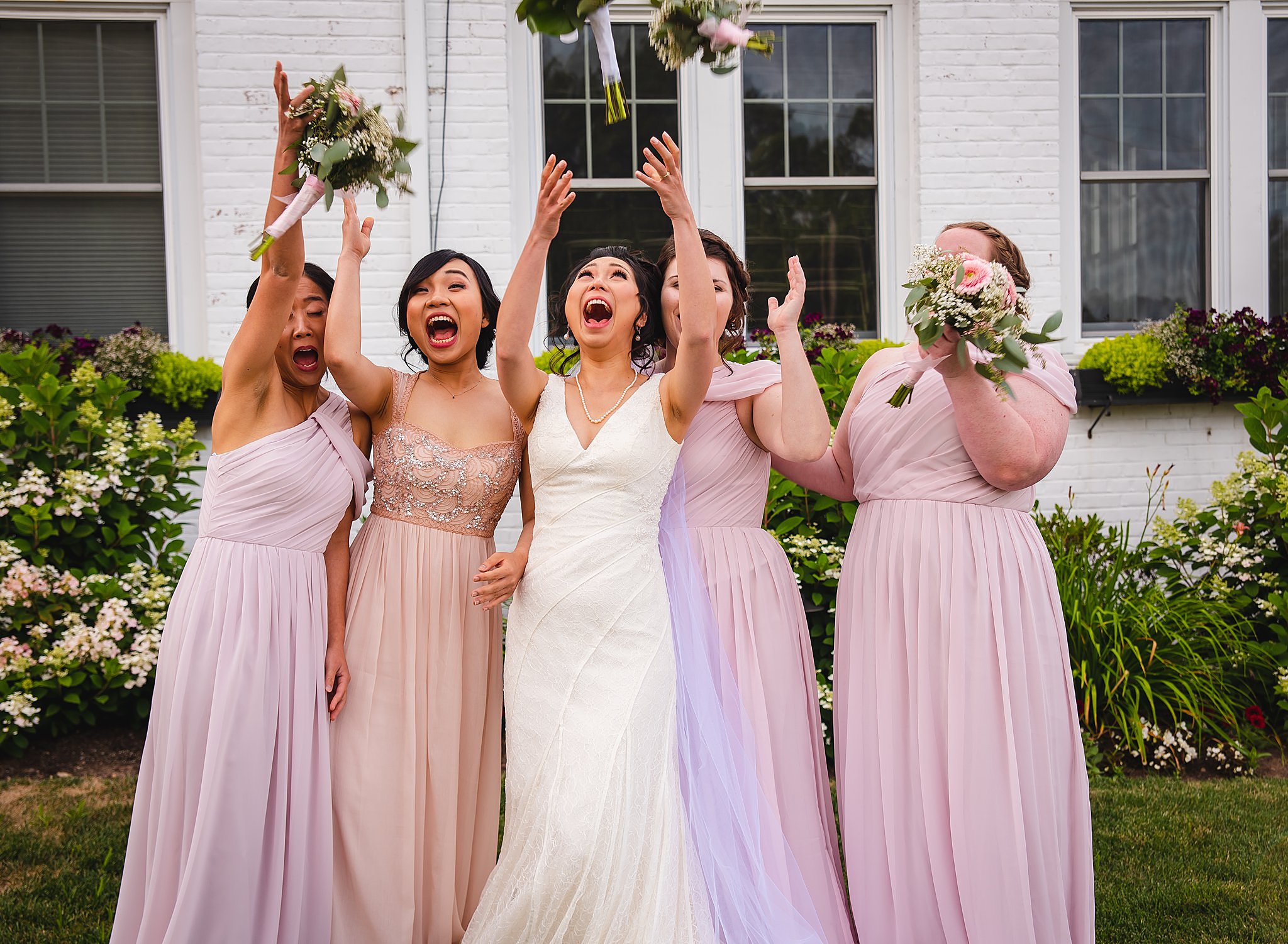 bride and bridesmaids tossing bouquets in air