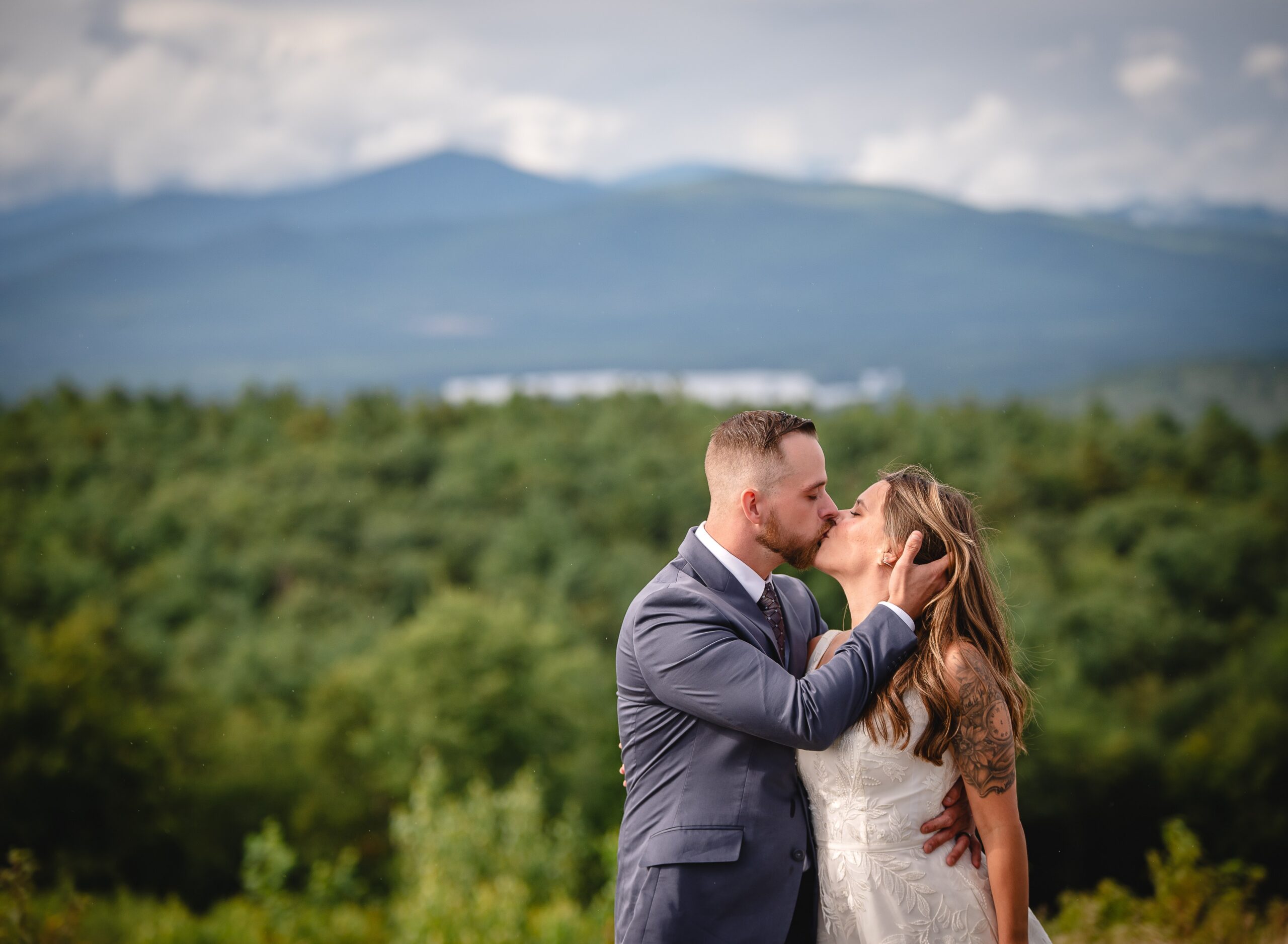 White Mountains elopement couple kissing with mountain range in background